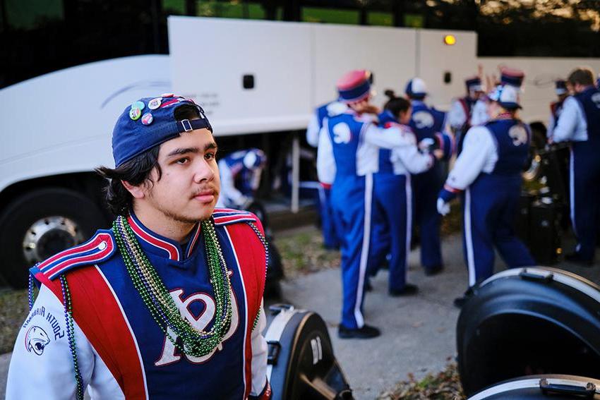 Guy with Jaguar Marching Band uniform and beads in Mardi Gras celebration